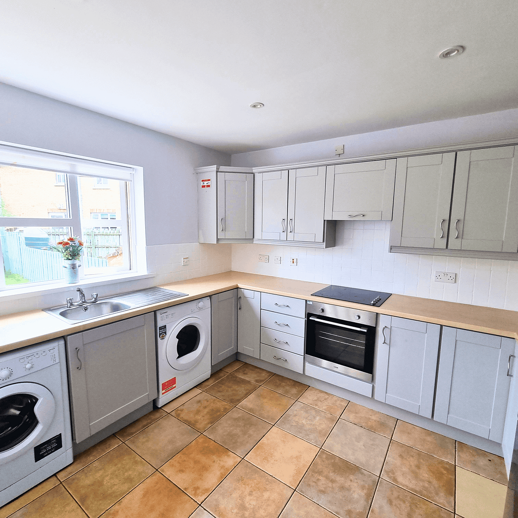 High-quality painted kitchen with light gray cabinets and modern appliances in Portstewart, showcasing professional interior painting services by G&E Interior Painting.
