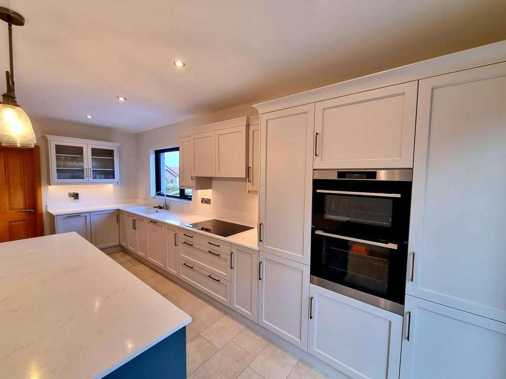 Bright white kitchen cabinets and modern built-in double oven in portstewart, expertly painted by G&E Interior Painting for a fresh, clean interior upgrade.