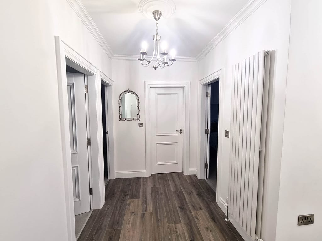 Modern hallway with white walls and chandelier