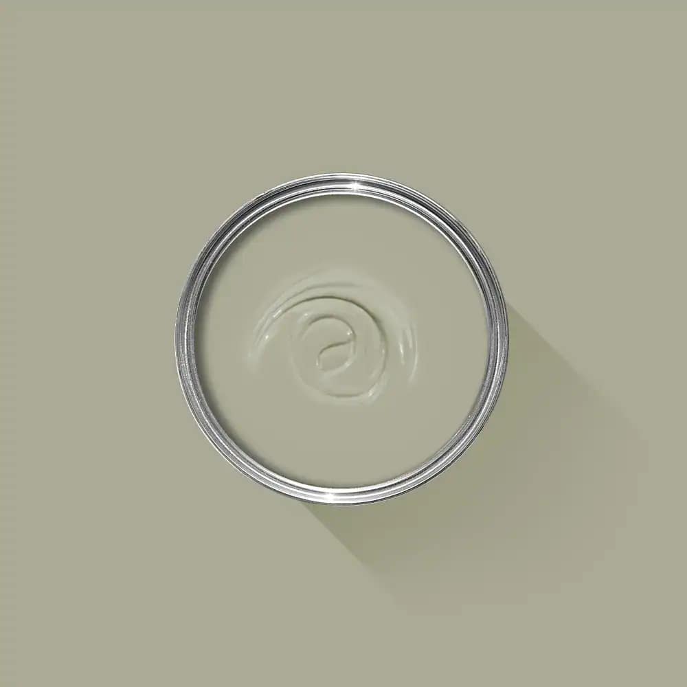Cream-colored interior paint in a metal can with a subtle shadow on a light beige wall, showcasing professional painting services by G&E Interior Painting in Portstewart.