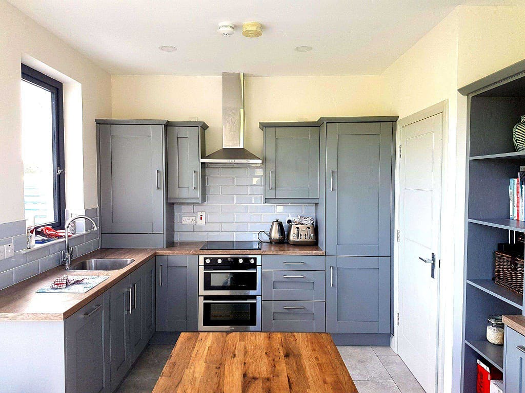 Modern kitchen with gray cabinets and island.
