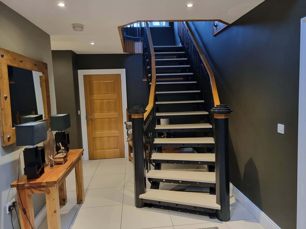 Elegant interior staircase painting with black and natural wood accents, showcasing expert home interior painting services in Portstewart for a stylish and modern look.