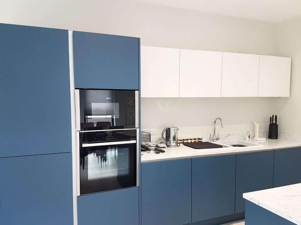 Sleek modern kitchen with blue and white cabinetry, showcasing professional interior painting services by G&E Interior Painting in Portstewart.