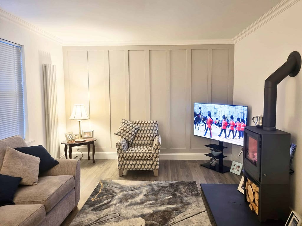 Bright living room featuring expertly painted neutral-colored walls, modern furniture, and a cozy fireplace, showcasing professional interior painting services in Portstewart.