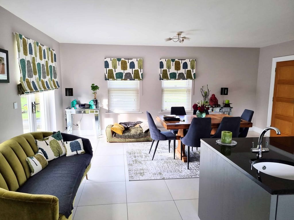 Bright interior of a modern living and dining area with freshly painted walls, featuring stylish window coverings and contemporary decor, showcasing professional interior painting services in Portstewart.