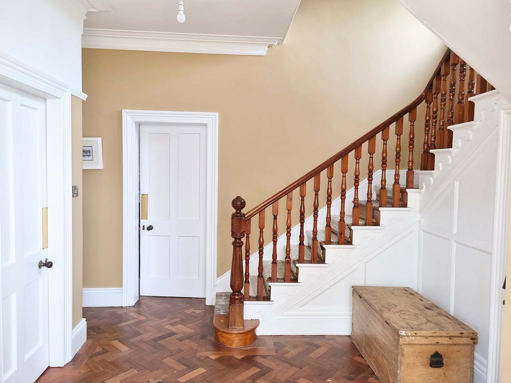 Brightly painted interior staircase with beige walls and white trim, showcasing expert interior painting services in Portstewart. Skilled craftsmanship enhances home elegance.