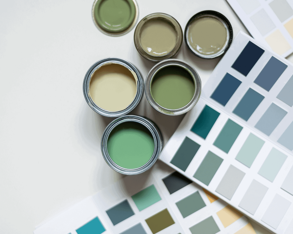 Vivid green and neutral paint cans with color swatches, showcasing high-quality interior painting supplies by G&E Interior Painting in Portstewart.