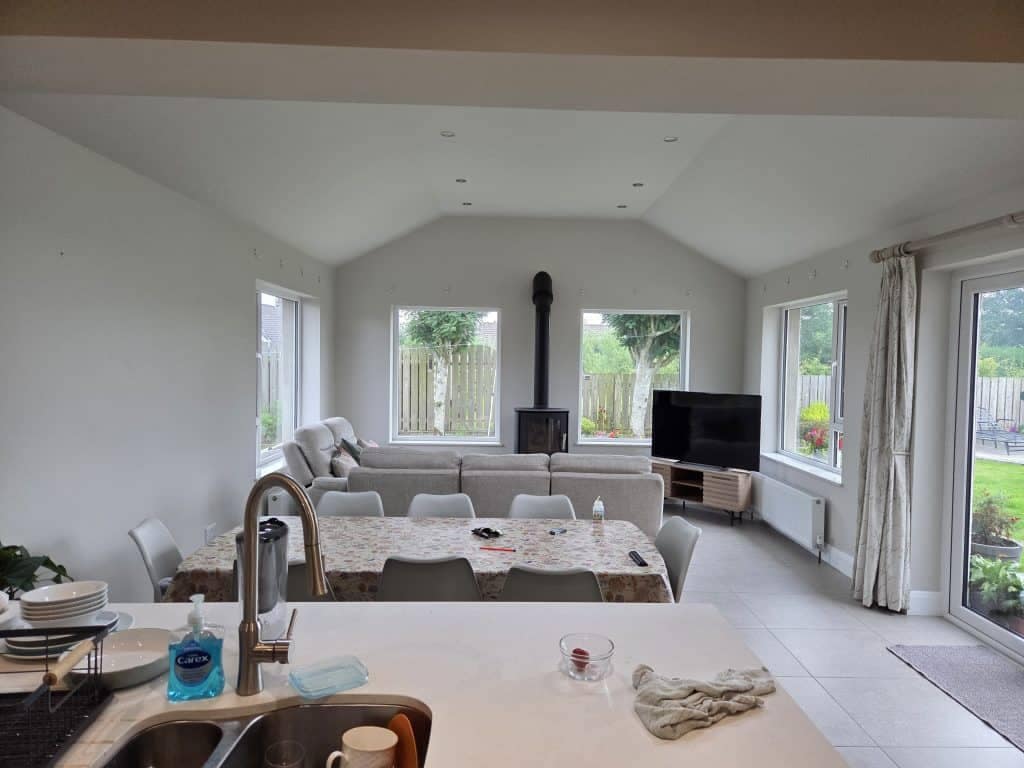 Bright interior living room with fresh white painted walls, large windows, modern furniture, and natural light, showcasing professional interior painting services in Portstewart.