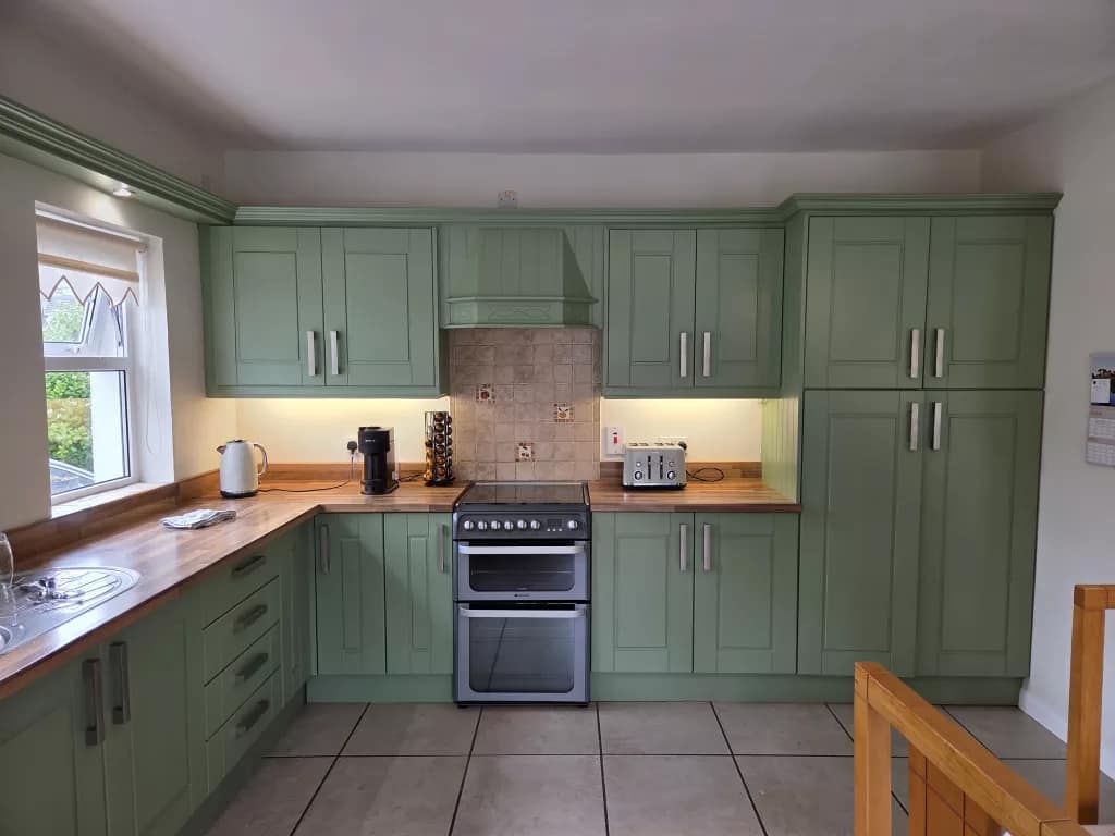 Breakfast room with elegant green hand-painted kitchen cupboards and bespoke finishes in coleraine