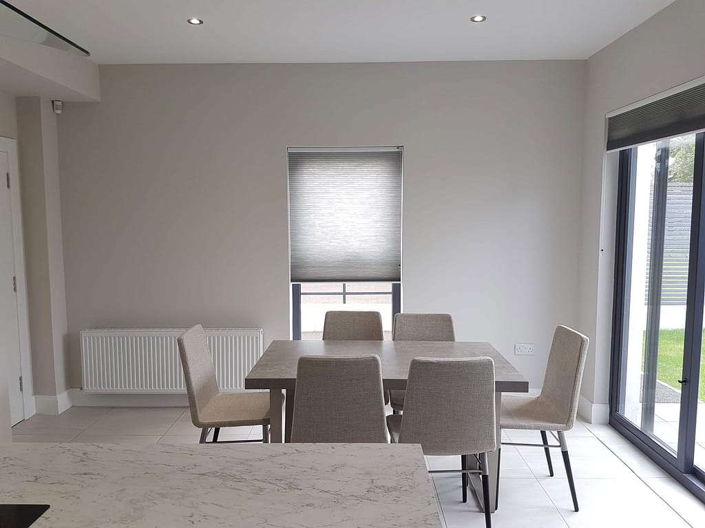 Modern dining room with neutral painted walls and large sliding glass doors, showcasing professional interior painting by G&E Interior Painting in castlerock creating a stylish and bright living space.