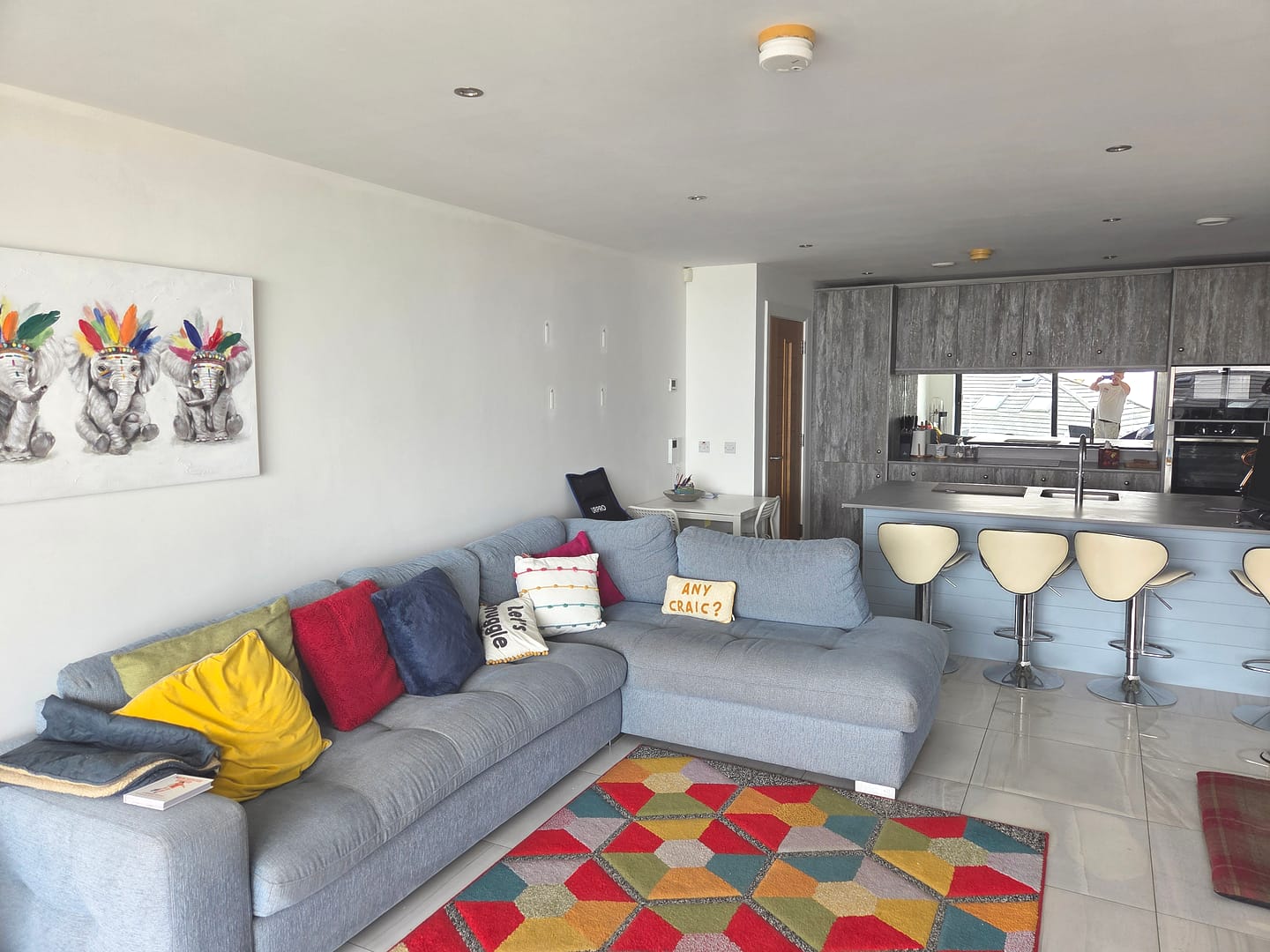 Interior painting project in Portrush featuring an open-plan living room and kitchen with freshly painted white walls and ceiling.